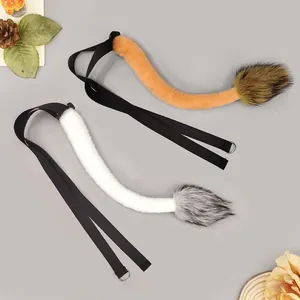 Detail view of plush lion tails in orange and white with adjustable elastic straps.