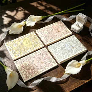 Elegant laser-cut wedding invitations in four macaron colors on a rustic wooden table