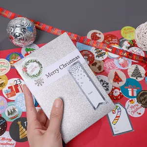 Close-up of a festive Merry Christmas sticker and ribbon on a glittery silver gift box decor