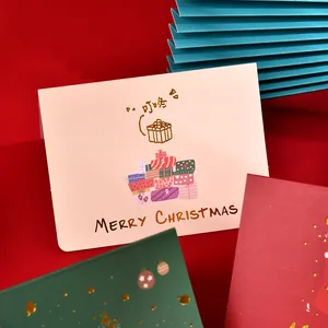 Detail of festive Christmas card with gold-stamped Merry Christmas text and gift illustrations