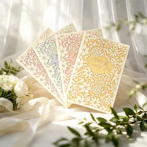 Close-up detail of four macaron-colored French hollow-cut wedding invitation cards with flowers
