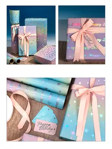 Nahaufnahme von holografischem Geschenkpapier mit Happy Birthday Anhängern und Schleife