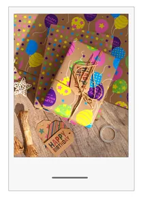 Detailed view of fluorescent balloon and star patterns on kraft birthday wrapping paper