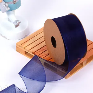 Detail view of dark blue organza ribbon on a craft cardboard spool for gift wrapping.