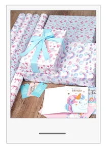 Lifestyle-Ansicht von traumhaften Geschenkpapierrollen mit rosa Schleifen und Regenbogen