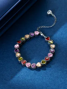 Close-up of heart-shaped colorful zircon stones on silver-toned bracelet detail.