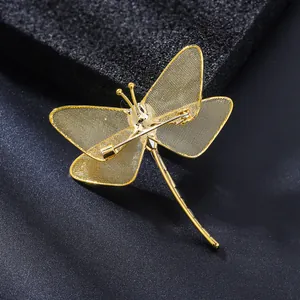 Detailed back view of golden dragonfly brooch with mesh wings and secure pin clasp