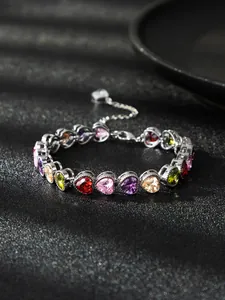 Close-up of elegant multicolored heart-shaped zircon bracelet on dark background