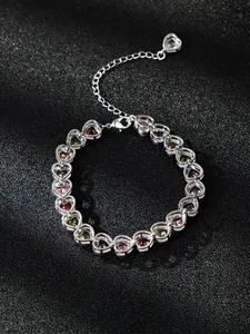 Detail view of heart-shaped silver bracelet with multi-colored cubic zirconia stones.