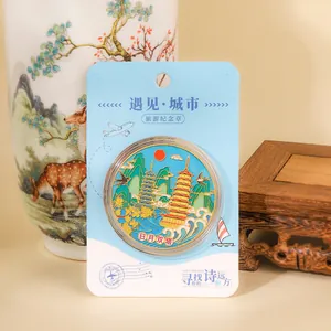 Detailed view of a Guilin Sun and Moon Twin Pagodas souvenir coin in its packaging.
