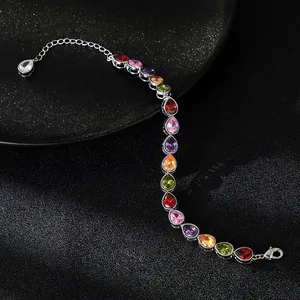 Macro detail of elegant multicolor pear-shaped zircon stones on silver bracelet link