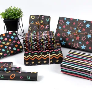 Variedad de papel de regalo negro con coloridos patrones de estrellas, rayas y geométricos.