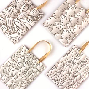 Elegante weiße Geschenktüten aus Papier mit goldenen Glitzerblattmustern und Bändern