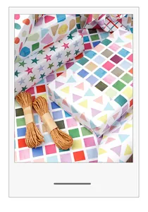 Detailed view of colorful geometric gift wrapping paper with decorative twine bundles