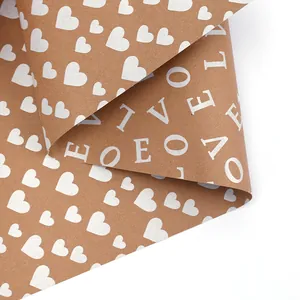 Detail of brown kraft gift wrapping paper with white heart and LOVE letter prints.