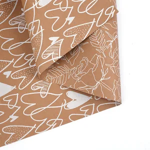 Macro detail of brown kraft wrapping paper with white heart and rose patterns.