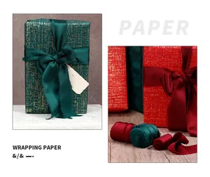 Close-up detail of luxurious textured green and red gift wrapping paper with silk ribbons