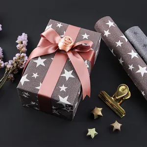 Glittery brown specialty wrapping paper with white stars and an elegant pink ribbon
