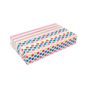 Close-up detail of double-sided gift wrapping paper with colorful polka dots and stripes