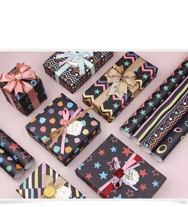 Diversi tipi di carta regalo nera e scatole con motivi colorati di stelle e strisce.