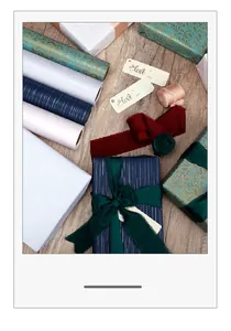 Detailed view of assorted luxury gift wrapping paper rolls and elegant silk ribbons