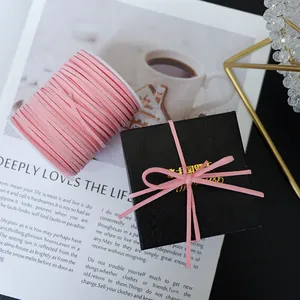 Soft pink velvet ribbon cord tied in a bow on a black gift box for floral decoration