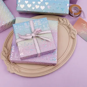 Dettaglio della carta da regalo olografica sfumata viola con motivi LOVE e cuori