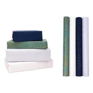 Detailed texture of luxury gift wrapping paper rolls in navy, teal, and silver shimmer.