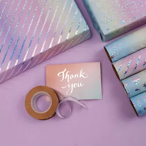 Dettaglio di carta regalo olografica viola con biglietto di ringraziamento e nastro