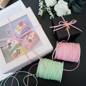 Detailed view of pink and mint green faux suede cords used for elegant gift packaging