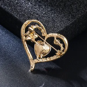 Detailed macro view of the gold-toned heart brooch back with safety pin clasp