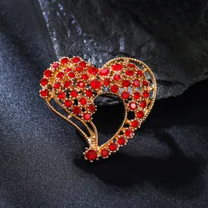 Elegant heart-shaped gold brooch with sparkling red rhinestones for women's suits.