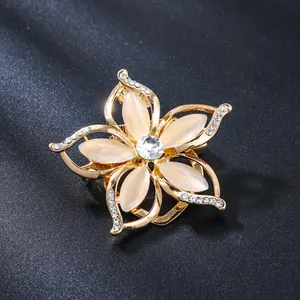 Elegant gold alloy flower brooch pin with cat eye stones and sparkling rhinestones