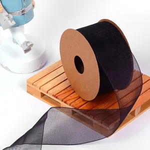 Close-up detail of black semi-transparent organza ribbon roll on decorative wooden pallet