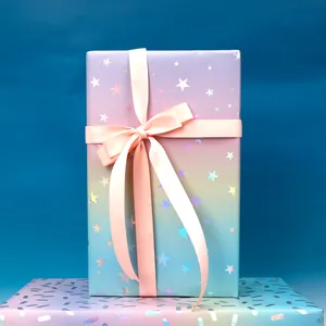 Nahaufnahme der laser-glänzenden Geschenkverpackung mit Sternenmuster und rosa Schleife