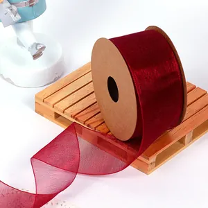 Close-up of wine red organza ribbon showing fine mesh texture on wooden pallet.