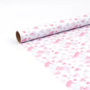 Detailopname van cadeaupapier op rol met roze aquarel hartjes voor verjaardagen.