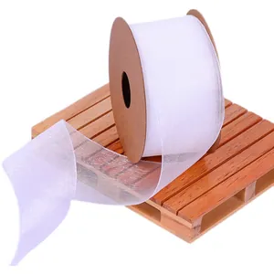 White sheer organza ribbon roll on wooden pallet for elegant gift wrapping and DIY crafts