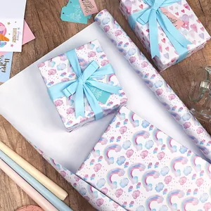 Cadeaupapier op rol met dromerig regenboog- en wolkenpatroon en lichtblauwe linten