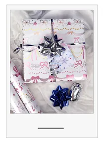 Detailansicht von rosa aluminisiertem Geschenkpapier mit Schleifen- und Schneeflockenmuster
