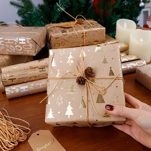 Dettaglio in primo piano di motivi natalizi in lamina d'oro su carta da regalo kraft marrone