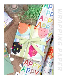 Primer plano de papel de regalo holográfico con globos de colores y texto Happy