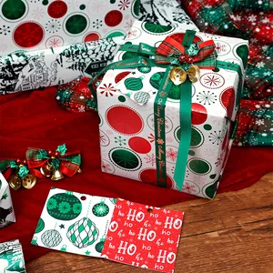 Detailed view of Christmas gift wrapping paper set with green ribbons and HO HO HO tags