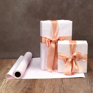 Rouleau de papier cadeau rose poudré haut de gamme et deux boîtes cadeau emballées