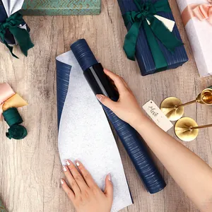 Gros plan de papier cadeau bleu texturé utilisé avec un coupe-papier très pratique