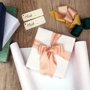 Détail d'un papier cadeau rose texturé de luxe avec un grand nœud en satin rose