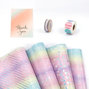 Carta da regalo olografica viola sfumata con motivi a cuore e strisce glitterate.