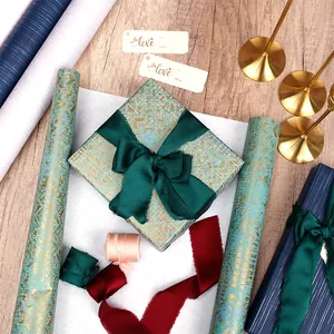Papier cadeau haut de gamme bleu sarcelle et or avec d'élégants rubans en soie