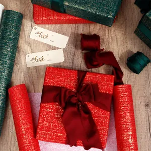 Détail de papier cadeau de luxe rouge et vert avec rubans de soie et étiquettes.
