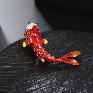 Close-up of elegant red koi fish brooch with enamel dripping and sparkling rhinestones.
